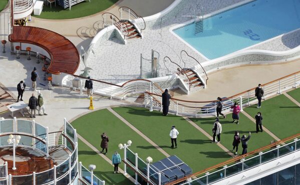 Пассажиры на палубе круизного судна Diamond Princess в порту Йокогамы Пассажиры на палубе круизного судна Diamond Princess в порту Йокогамы