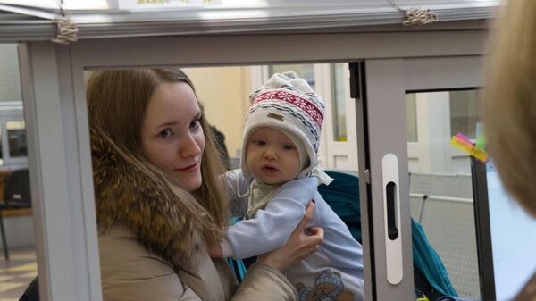 Молодая женщина с ребенком получает консультацию у сотрудницы центра занятости Молодая женщина с ребенком получает консультацию у сотрудницы центра занятости