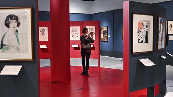 Посетительница фотографирует картины на выставке художника Юрия Анненкова Революция за дверью в музее русского импрессионизма в Москве