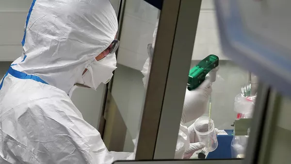 Работник лаборатории во Франции во время манипуляций с образцами пробы потенциально зараженного коронавирусом пациента 