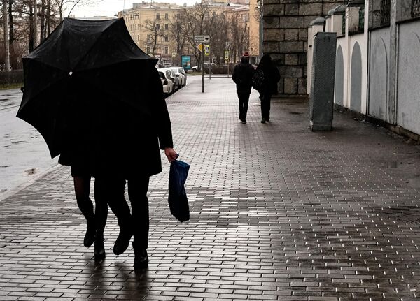 Прохожие с зонтиком на улице Санкт-Петербурга, где объявлен оранжевый уровень опасности из-за усиления ветра. 17 февраля 2020 Прохожие с зонтиком на улице Санкт-Петербурга, где объявлен оранжевый уровень опасности из-за усиления ветра. 17 февраля 2020