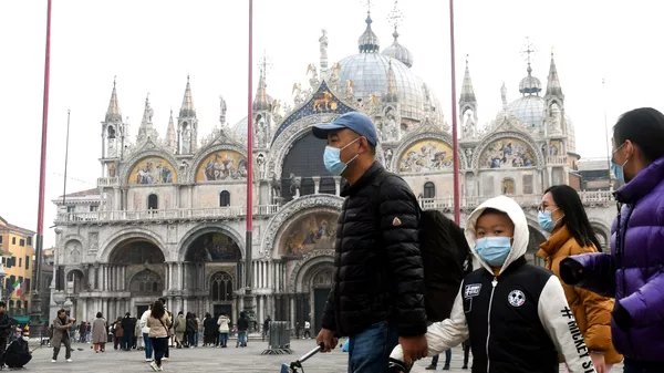 Туристы в медицинских масках на площади Святого Марко в Венеции. 24 февраля 2020 