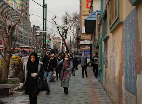 Люди в медицинских масках на улице столицы Ирана города Тегеран Люди в медицинских масках на улице столицы Ирана города Тегеран