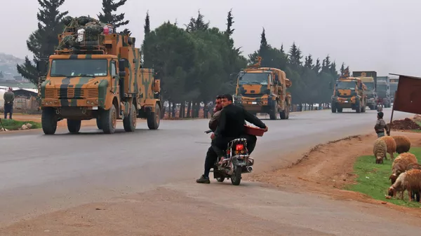 Местные жители пропускают колонну турецкой военной техники в провинции Идлиб, Сирия. 28 февраля 2020
