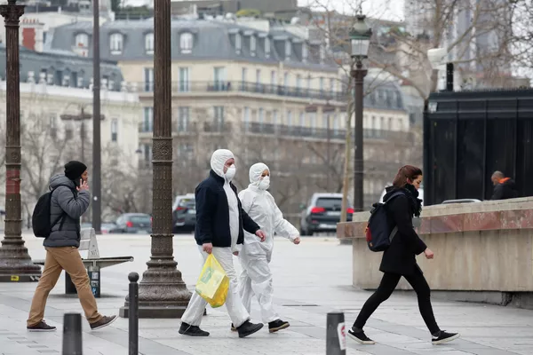 Люди в защитных костюмах в Париже