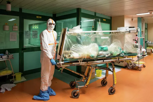 Медицинские работники в защитных костюмах транспортируют больного коронавирусом в больницу Коламбус Ковид, Италия