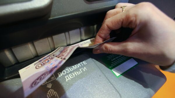 Женщина получает наличные деньги в банкомате Женщина получает наличные деньги в банкомате