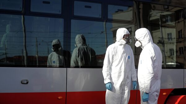 Рабочие в защитных костюмах готовятся во время дезинфекции трамваев в Праге Рабочие в защитных костюмах готовятся во время дезинфекции трамваев в Праге