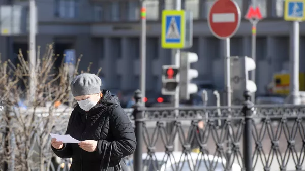 Женщина в защитной маске на одной из улиц в Москве