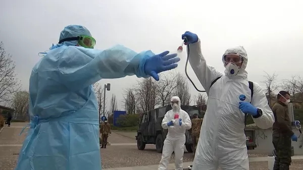 Российские военные специалисты в костюмах бактериологической защиты в лечебном учреждении в Бергамо