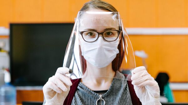 Девушка демонстрирует готовый лицевой экран для индивидуальной защиты глаз, дыхательных путей и лица медицинских работников в технопарке Кванториум. Новатория Девушка демонстрирует готовый лицевой экран для индивидуальной защиты глаз, дыхательных путей и лица медицинских работников в технопарке Кванториум. Новатория