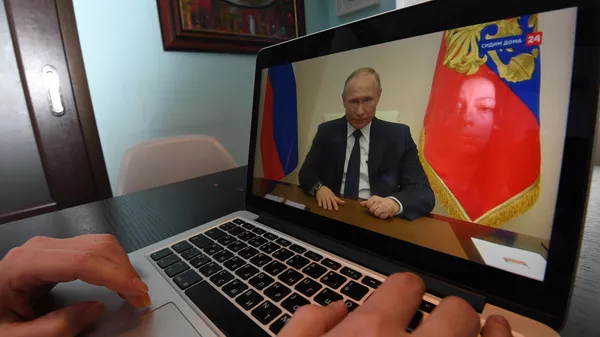 Жительница Москвы смотрит трансляцию обращения президента РФ Владимира Путина к гражданам