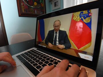 Жительница Москвы смотрит трансляцию обращения президента РФ Владимира Путина к гражданам Жительница Москвы смотрит трансляцию обращения президента РФ Владимира Путина к гражданам