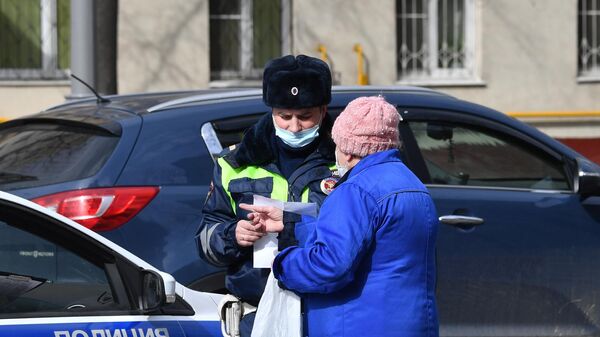 Сотрудник полиции общается с жительницей Москвы в дни режима самоизоляции граждан в связи с распространением коронавируса Сотрудник полиции общается с жительницей Москвы в дни режима самоизоляции граждан в связи с распространением коронавируса