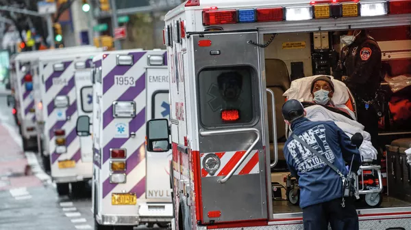Пациент в машине скорой помощи возле медицинского центра NYU Langone в Нью-Йорке