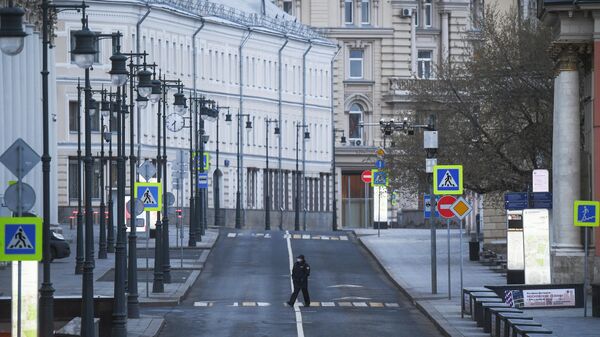 Сотрудница полиции переходит дорогу во время режима самоизоляции жителей в Москве