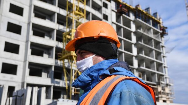 Рабочий в медицинской маске на строительстве жилого комплекса в Новосибирске Рабочий в медицинской маске на строительстве жилого комплекса в Новосибирске