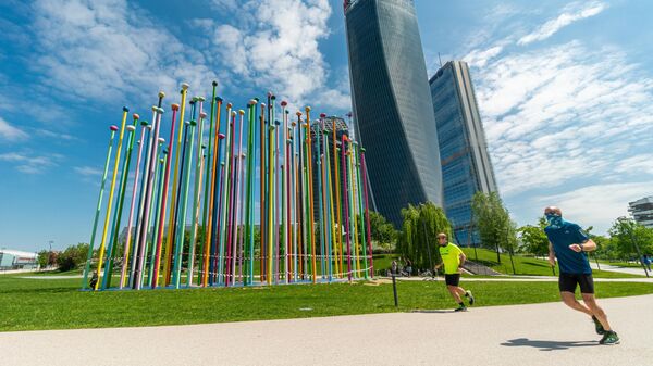 Мужчины совершают пробежку у небоскреба Generali Tower в Милане Мужчины совершают пробежку у небоскреба Generali Tower в Милане