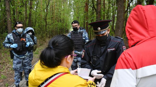 Сотрудник полиции совместно с сотрудниками Росгвардии проверяют документы у прохожих в Бирюлевском лесопарке Москвы Сотрудник полиции совместно с сотрудниками Росгвардии проверяют документы у прохожих в Бирюлевском лесопарке Москвы