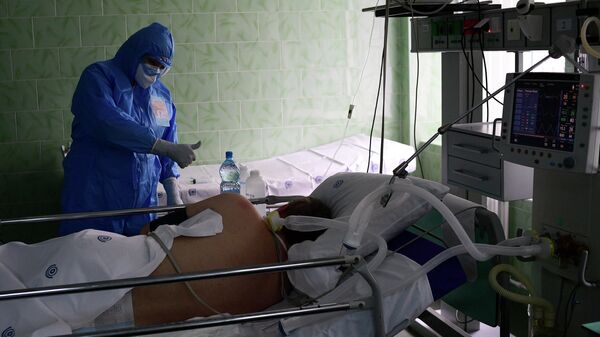 Врач и пациент в отделении реанимации и интенсивной терапии городской клинической больницы имени В. В. Виноградова, переоснащенной для лечения пациентов с COVID-19 Врач и пациент в отделении реанимации и интенсивной терапии городской клинической больницы имени В. В. Виноградова, переоснащенной для лечения пациентов с COVID-19