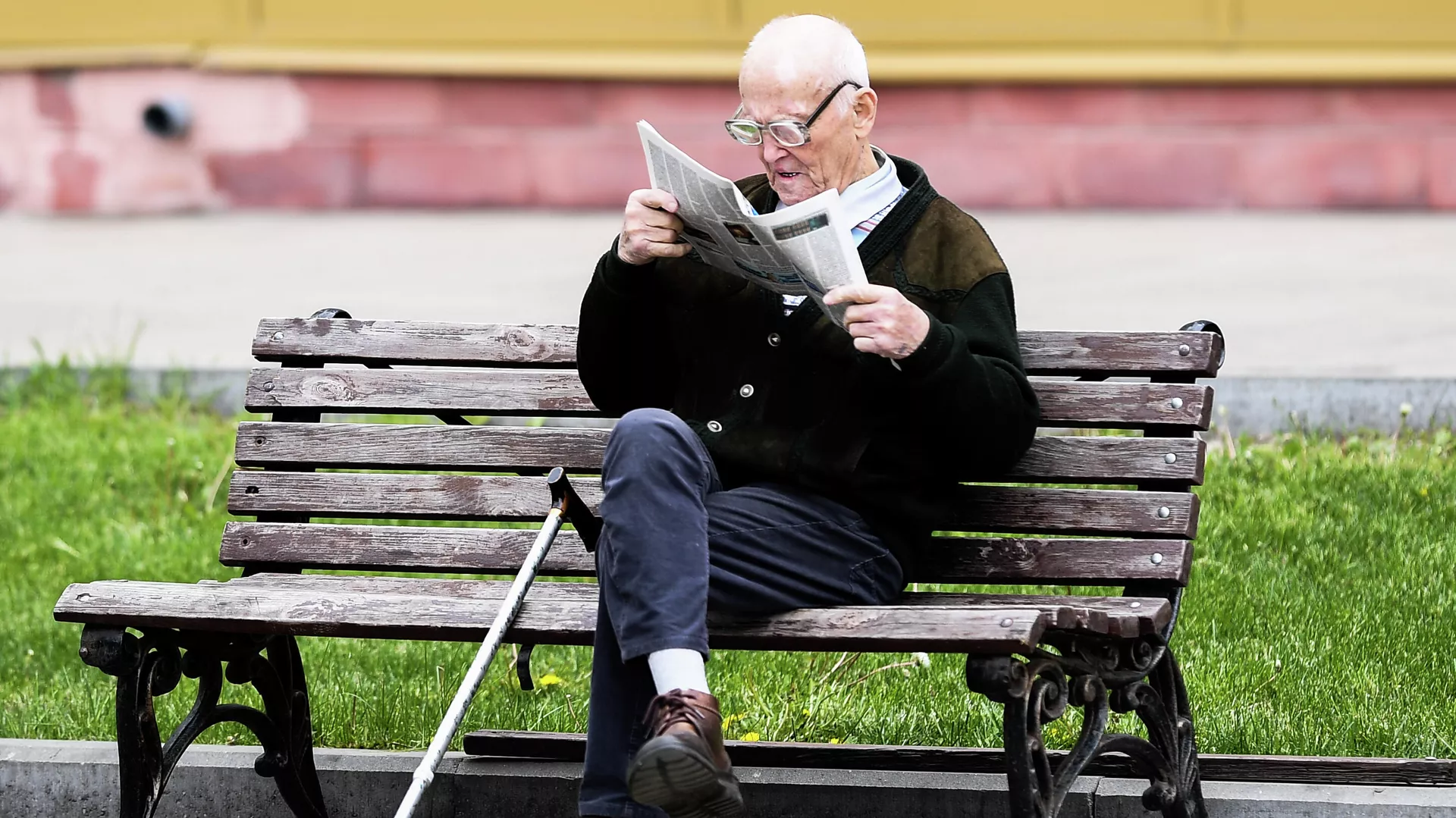 Мужчина читает газету на улице на лавочке в Москве - РИА Новости, 1920, 20.08.2020