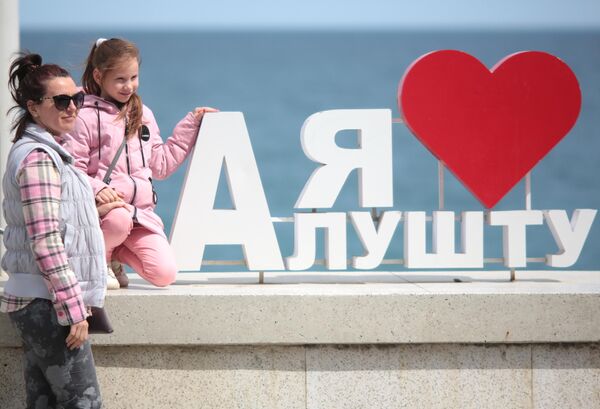Женщина с ребенком на набережной Алушты после отмены режима самоизоляции в Крыму Женщина с ребенком на набережной Алушты после отмены режима самоизоляции в Крыму