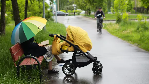 Женщина с детской коляской на Жулебинском бульваре в Москве
