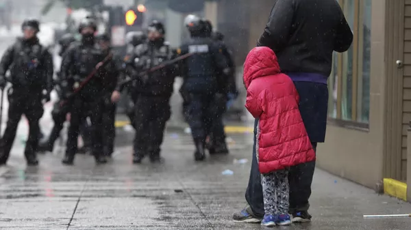 Девочка рядом с отцом во время протестов в Вашингтоне 
