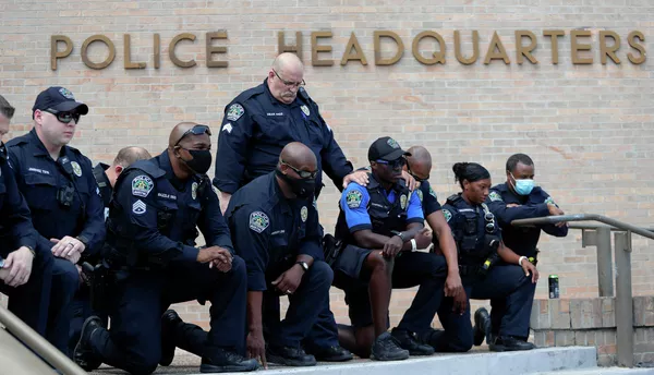Полицейские преклоняют колени перед демонстрантами, которые собрались в Остине, штат Техас