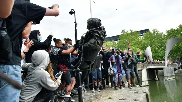 Протестующие бросают статую работорговца Эдварда Кольстона в гавань Бристоля во время акции протеста Black Lives Matter