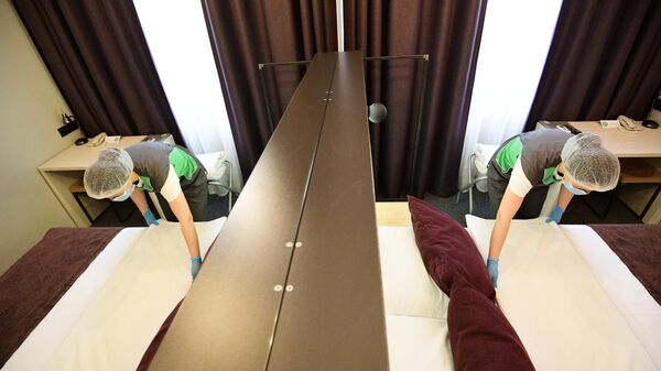 Горничная застилает кровать в номере отеля Library в Москве