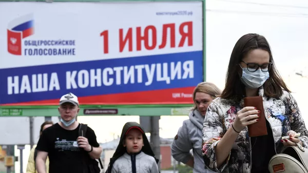 Прохожие около баннера, информирующего об общероссийском голосовании по поправкам в Конституцию РФ, в Новосибирске