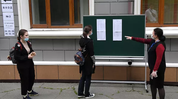 Школьница ищет свою фамилию в списках на сдачу перед началом единого государственного экзамена в средней общеобразовательной школе №13 Владивостока
