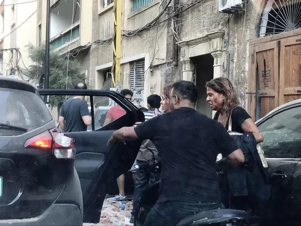 Люди, пострадавшие от осколков витрин, выбитых в результате взрыва в районе порта в Бейруте