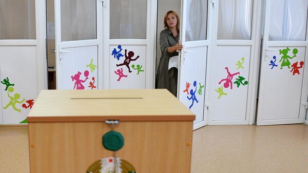 Женщина голосует на выборах президента Белоруссии на избирательном участке в Минске Женщина голосует на выборах президента Белоруссии на избирательном участке в Минске