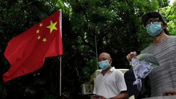 Участники акции протеста против санкций США у консульства США в Гонконге
