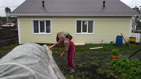 Местная жительница Татьяна Долгих во дворе нового дома в микрорайоне Березовая роща в городе Тулун Иркутской области. Местная жительница Татьяна Долгих во дворе нового дома в микрорайоне Березовая роща в городе Тулун Иркутской области.