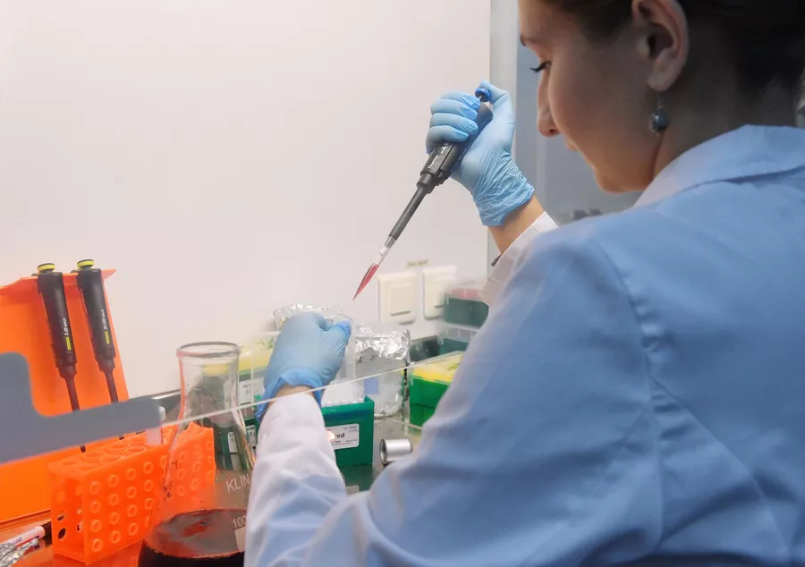 Сотрудница лаборатории проводит испытания вакцины от COVID-19