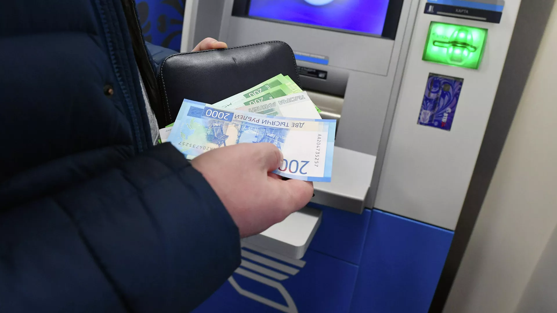 Женщина производит снятие денег в банкомате Женщина производит снятие денег в банкомате - РИА Новости, 1920, 29.09.2020