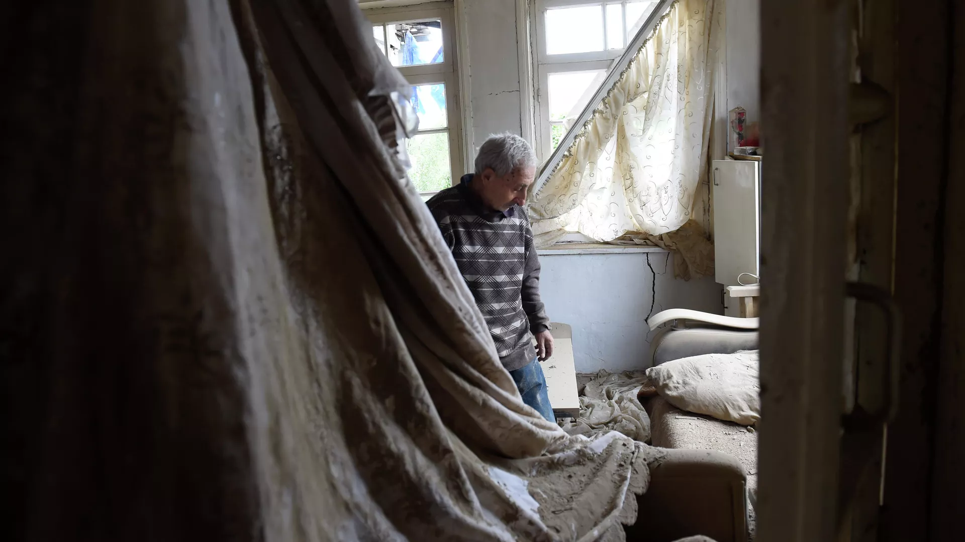 Местный житель показывает комнату пострадавшего после обстрелов дома в городе Мартуни непризнанной Нагорно-Карабахской Республики - РИА Новости, 1920, 29.09.2020