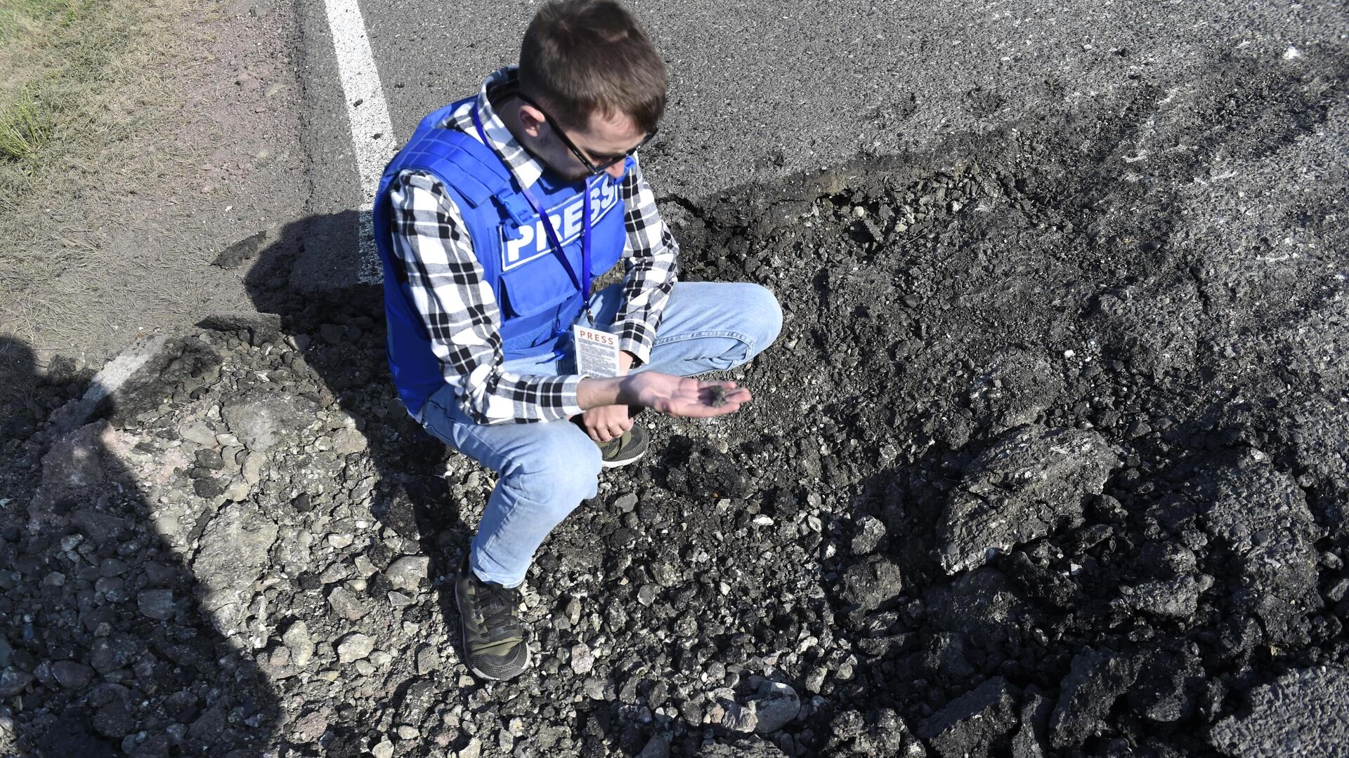 Журналист держит в руках осколок от снаряда в Мартакертском районе Нагорного Карабаха Журналист держит в руках осколок от снаряда в Мартакертском районе Нагорного Карабаха - РИА Новости, 1920, 01.10.2020