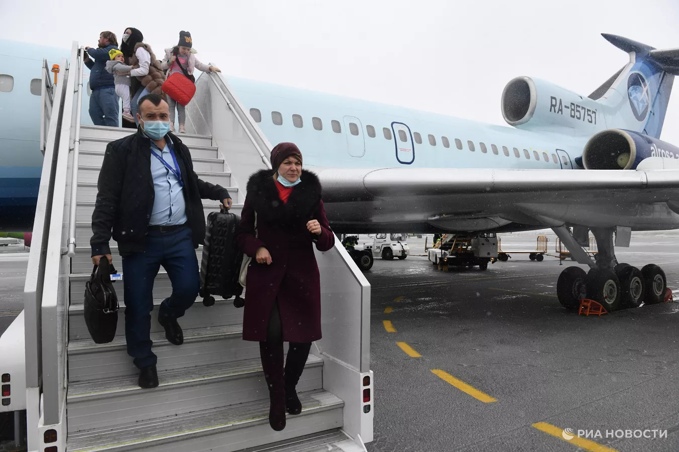 people walking up stairs of an airplane