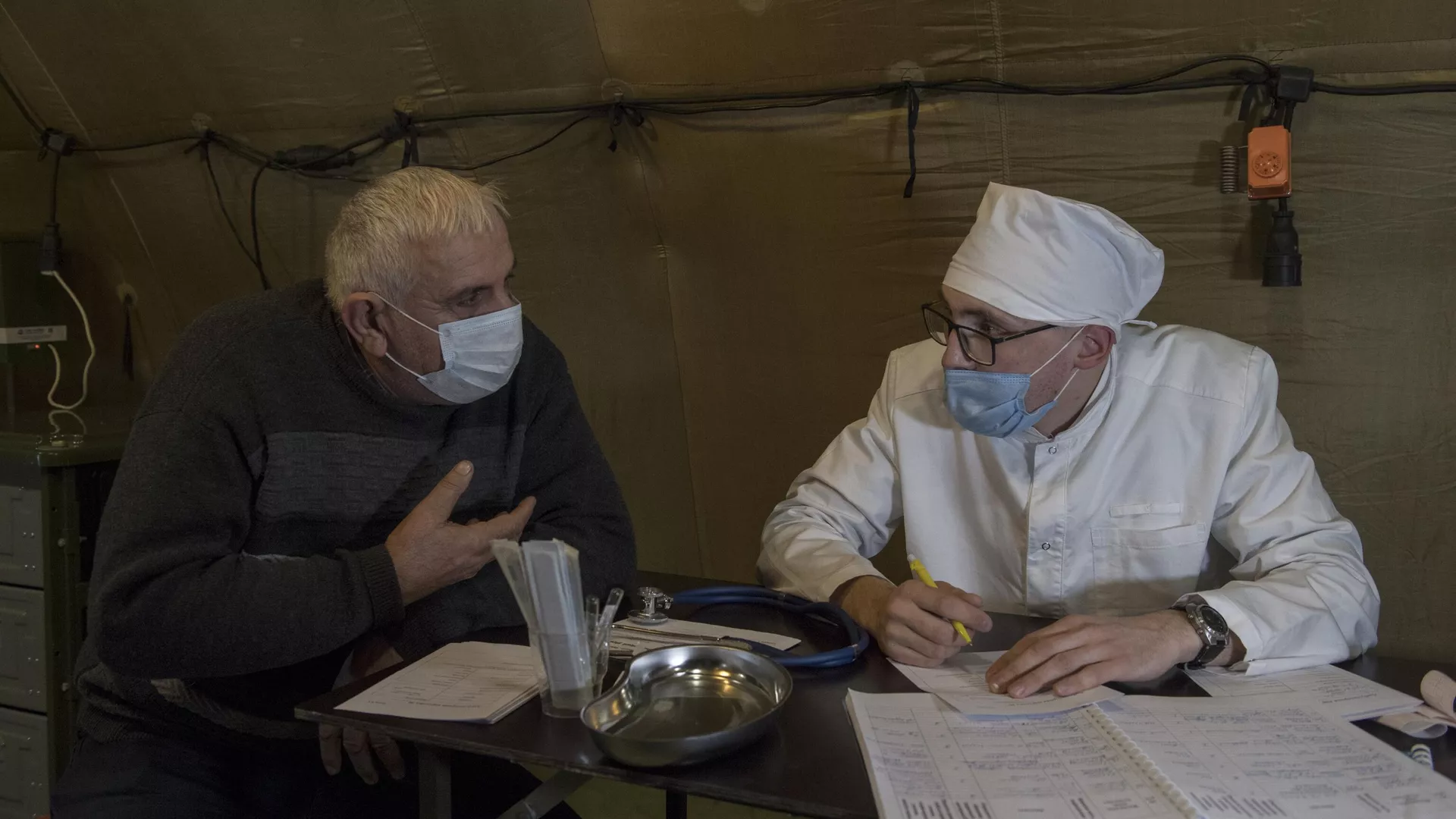 Врач проводит прием пациента на базе госпиталя развернутого Министерством обороны России на территории аэропорта в Степанакерте - РИА Новости, 1920, 08.12.2020