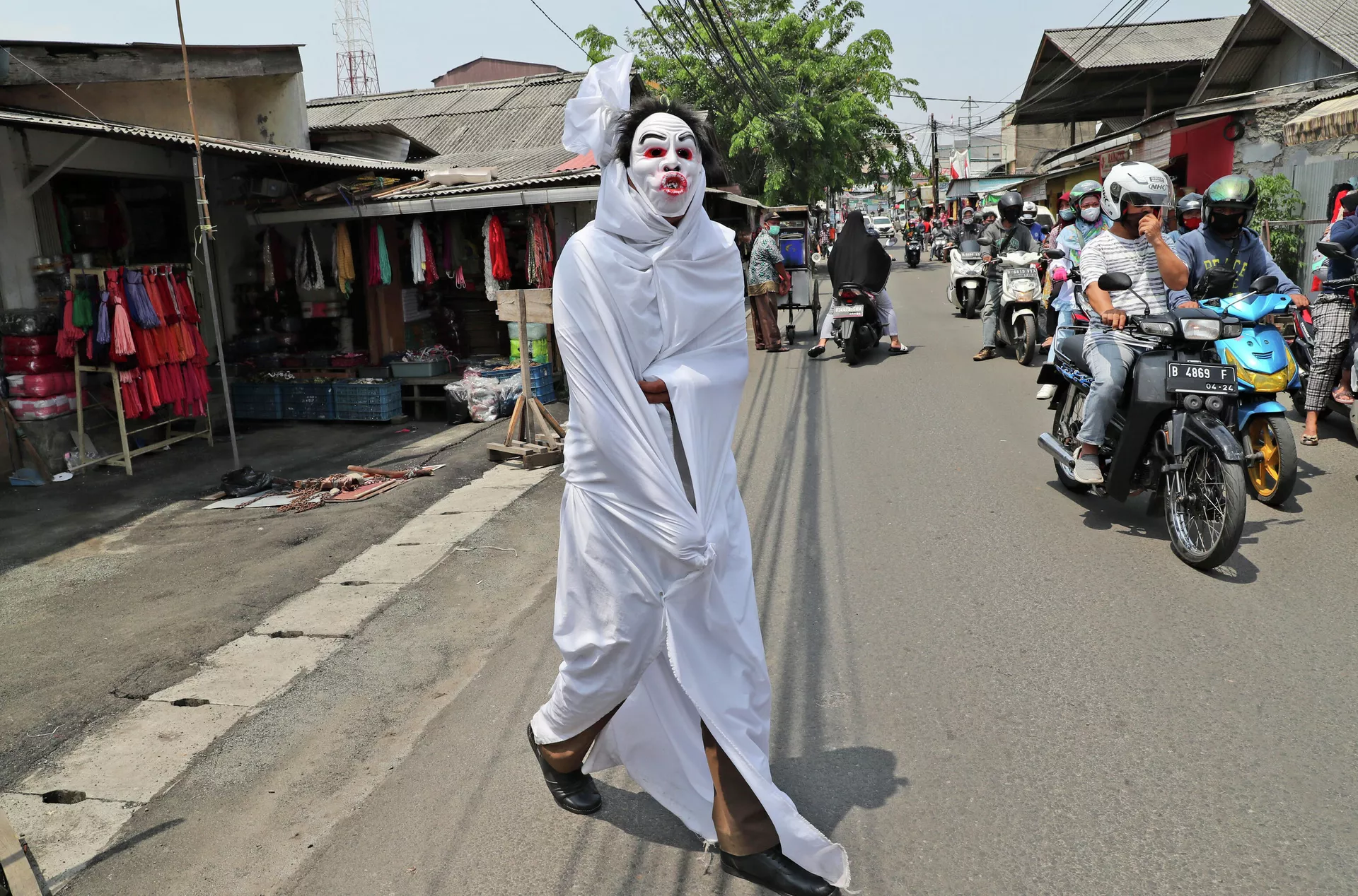 Волонтер, одетый в костюм приведения из местного фольклора, чтобы пугать нарушителей самоизоляции в Индонезии - РИА Новости, 1920, 22.12.2020