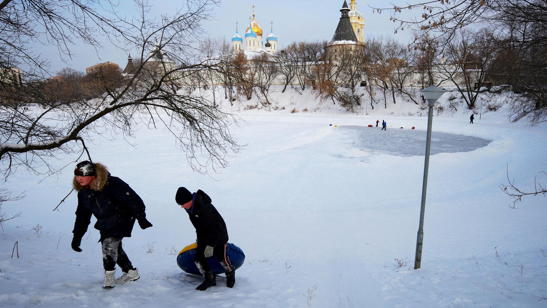 Дети катаются на ватрушке возле Новоспасского монастыря в Москве Дети катаются на ватрушке возле Новоспасского монастыря в Москве - РИА Новости, 1920, 18.01.2021