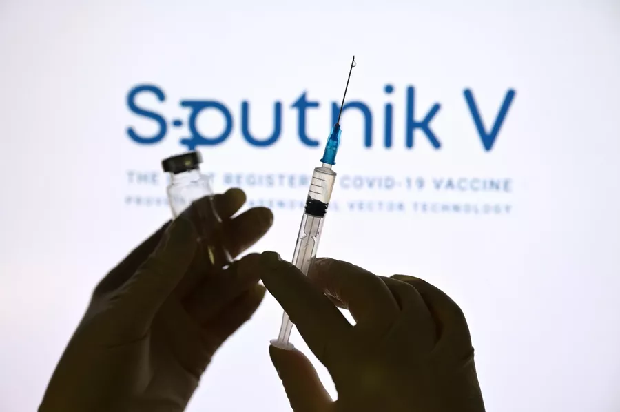 Шприц и ампула на фоне логотипа вакцины Спутник V