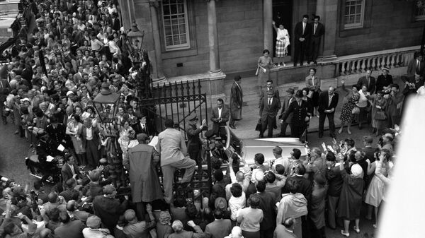 Люди залезают на ворота у советского посольства в Лондоне, 11 июля 1961 года, чтобы лучше разглядеть российского космонавта Юрия Гагарина, который стоит в открытом Rolls-Royce. Он приехал в Лондон на советскую выставку Люди залезают на ворота у советского посольства в Лондоне, 11 июля 1961 года, чтобы лучше разглядеть российского космонавта Юрия Гагарина, который стоит в открытом Rolls-Royce. Он приехал в Лондон на советскую выставку
