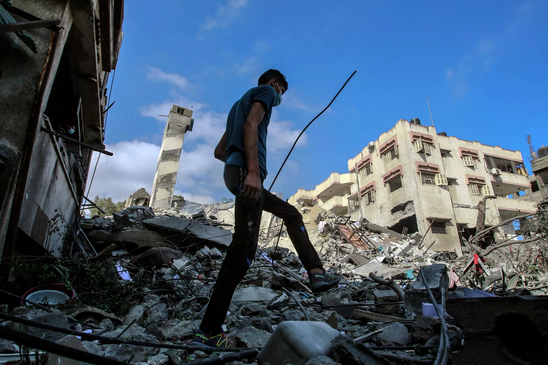 شاب في موقع المباني التي دمرها القصف في قطاع غزة - ريا نوفوستي ، 1920 ، 19/05/2021