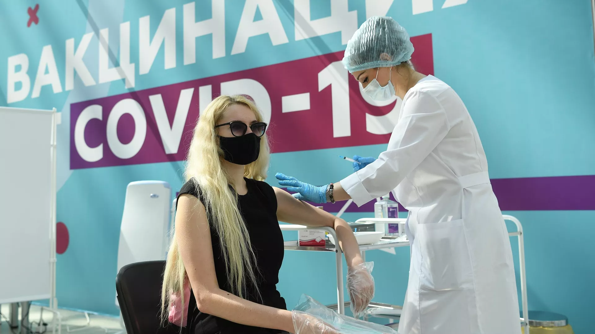 Медицинский сотрудник делает посетителю прививку в центре вакцинации от COVID-19 в Гостином дворе - РИА Новости, 1920, 05.08.2021