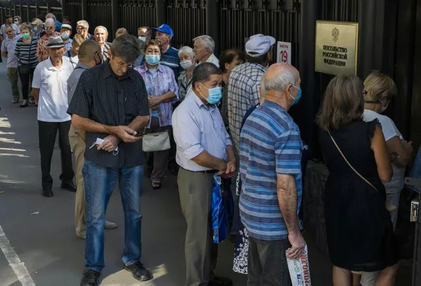Люди стоят в очереди у входа на избирательный участок №8159 в посольстве России в Киргизии, чтобы проголосовать на выборах депутатов Государственной Думы РФ